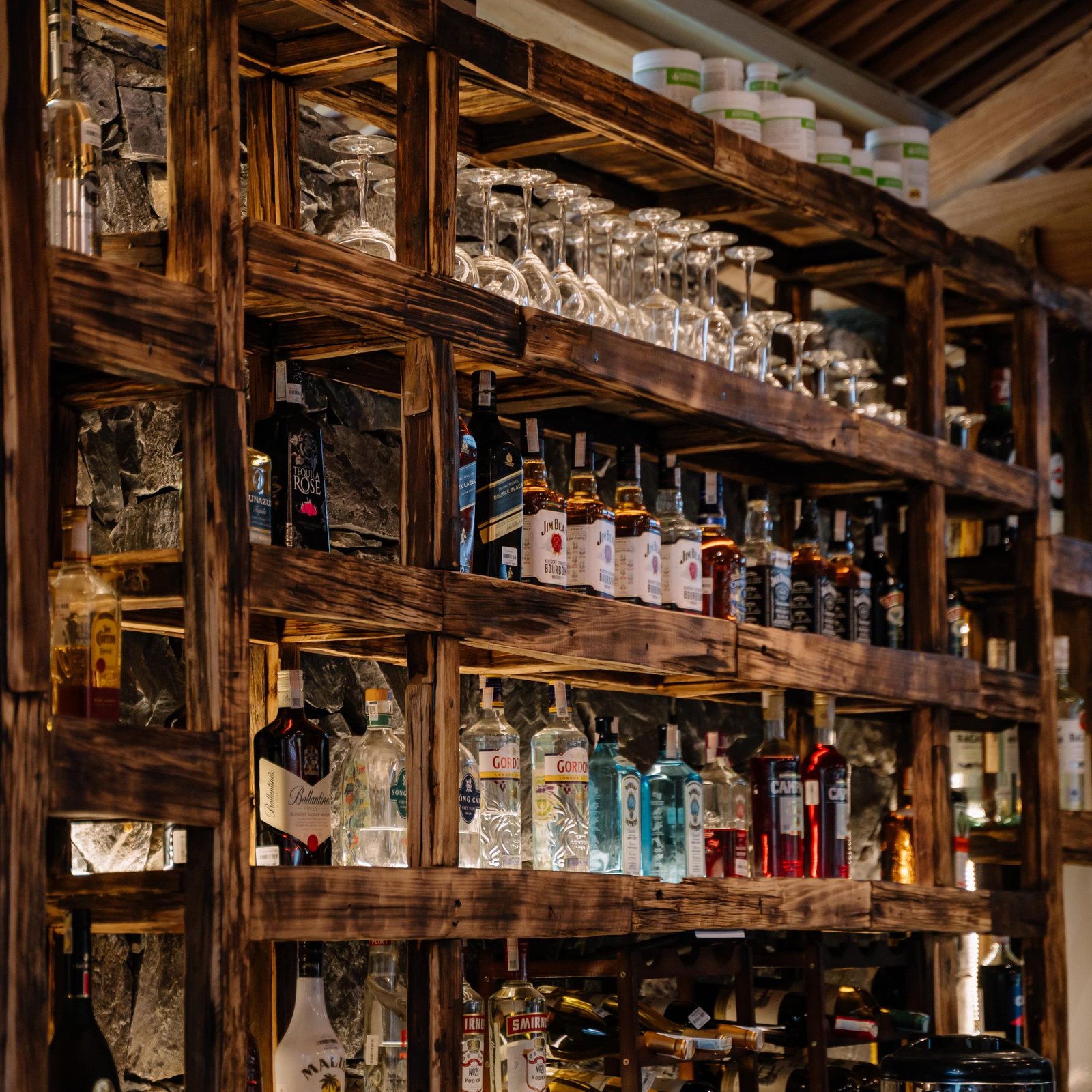 Spirits and glassware on the bar shelves at Anans Home